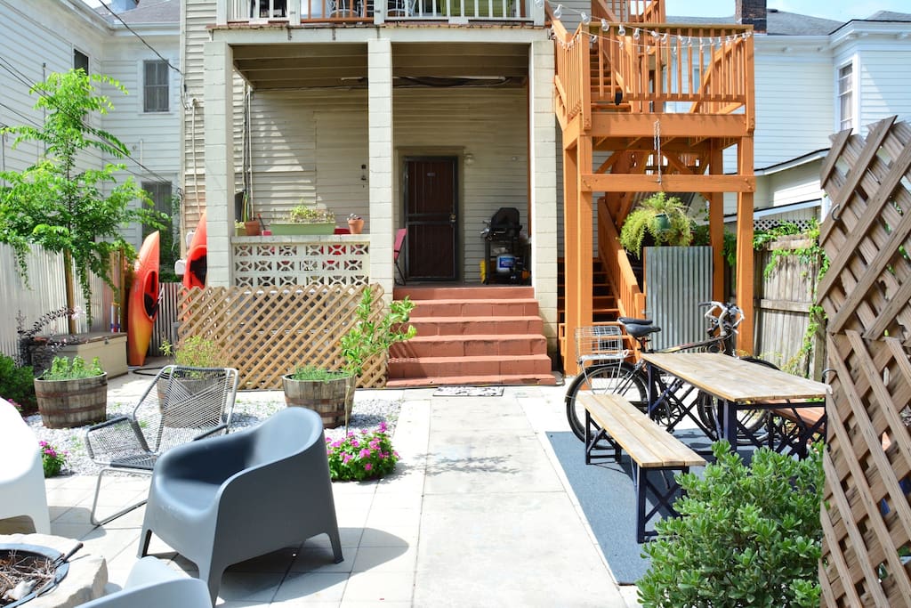 Backyard with fire pit, bikes, table, grill and kayaks.