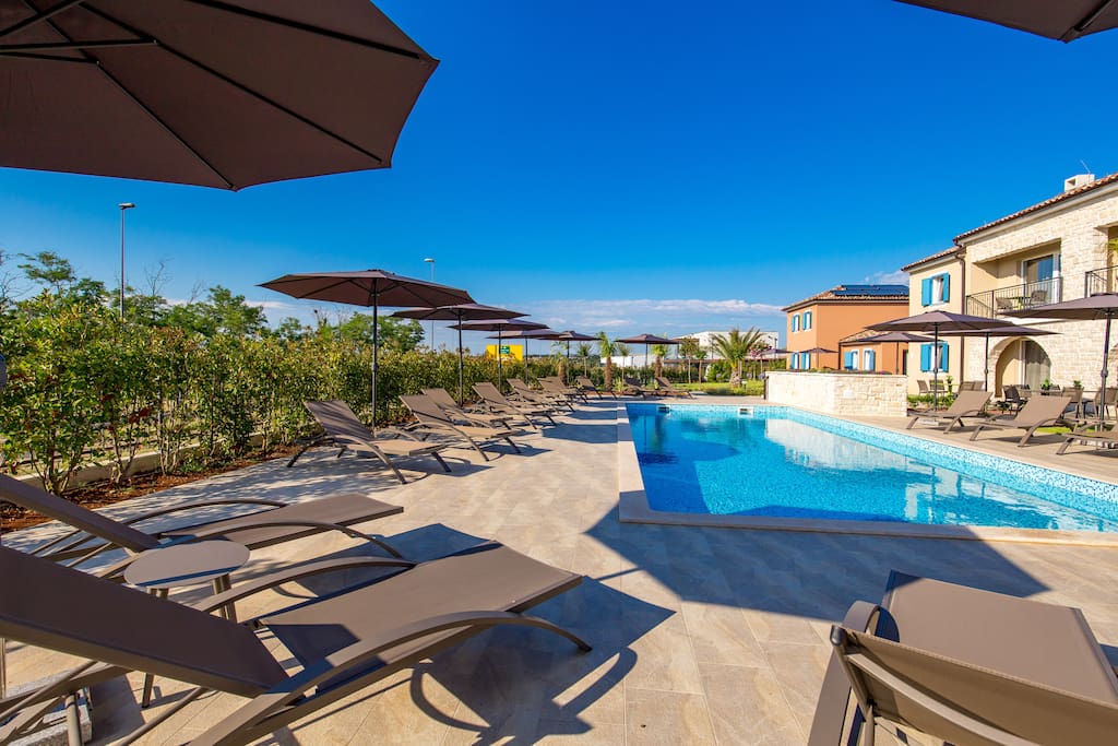 Pool with deck chairs and umbrellas