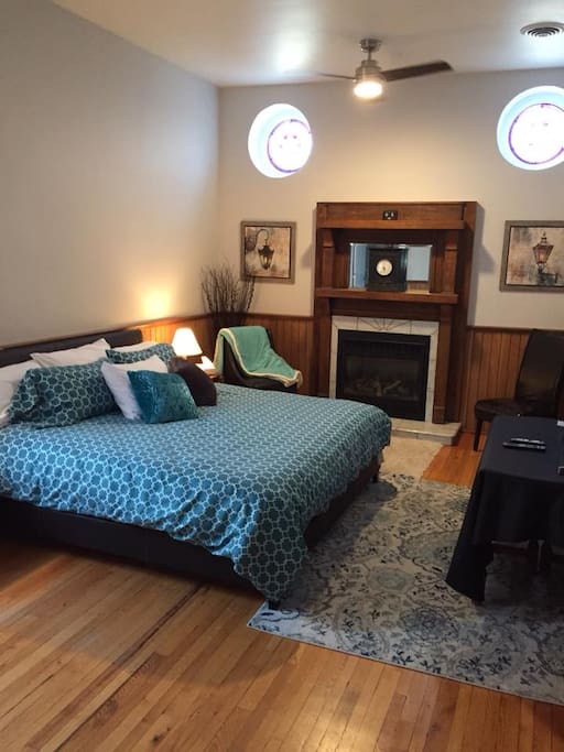 The King Suite with king bed, gas fireplace, stained glass windows, smart TV, wainscotting and ensuite bathroom.