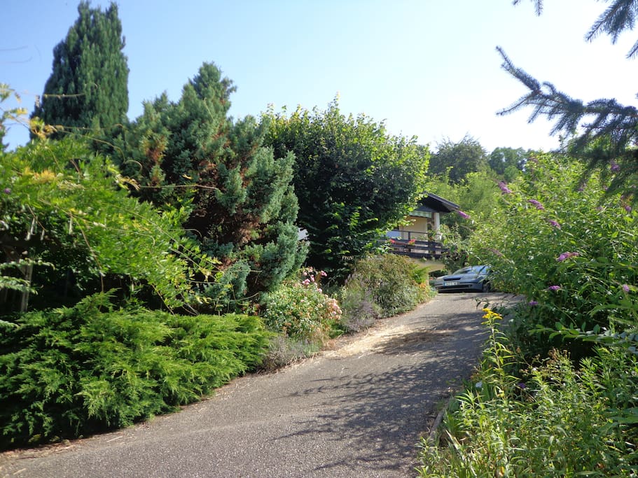 Montée très verdoyante, et esplanade pour déposer les valises.