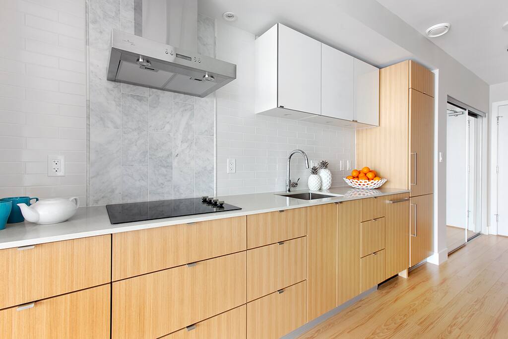 Modern, open concept kitchen, with lots of counter space. Blomberg and Fulgor stainless appliances, a ceramic electric cook-top, oven, dishwasher, built-in microwave and garburator.