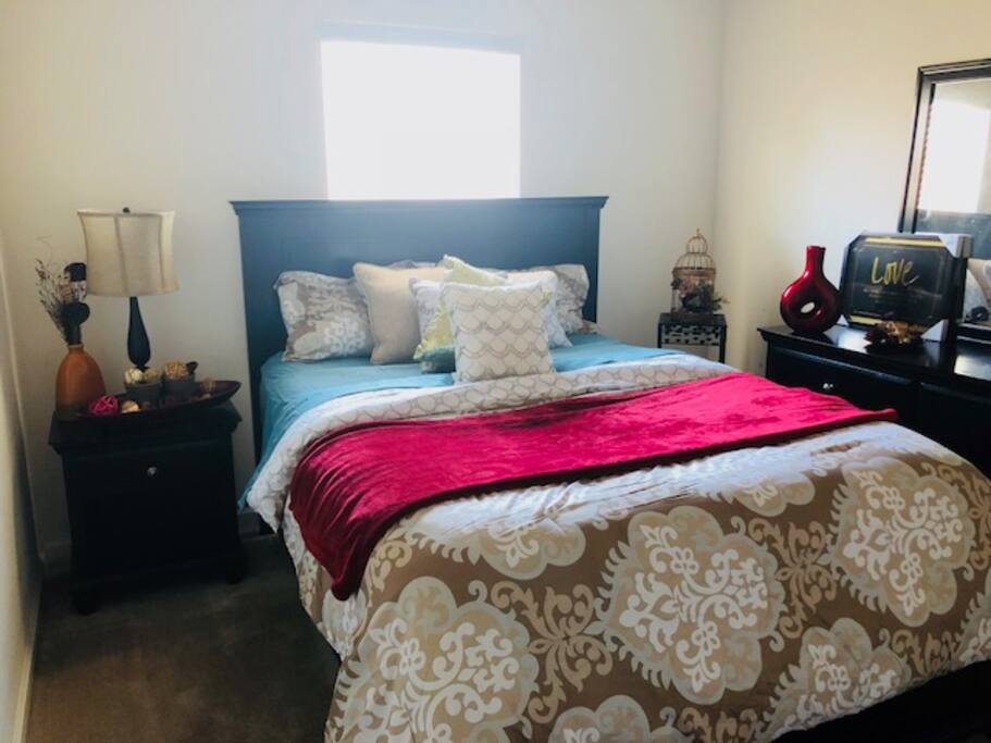 Queen bed in room w/ large flat screen tv