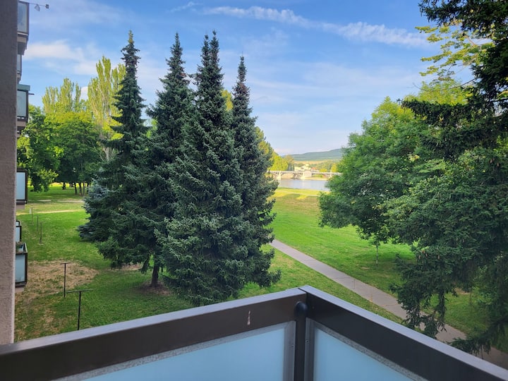Apartment with a view of the water and greenery.