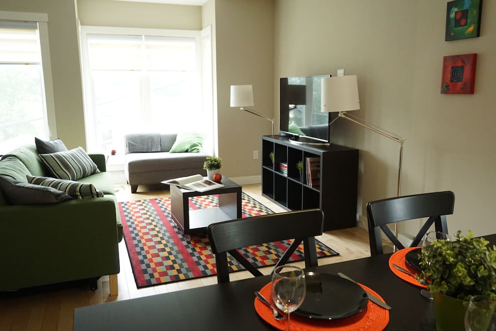 Living room with queen sofabed and 50" 4K TV. Sunny alcove for reading.