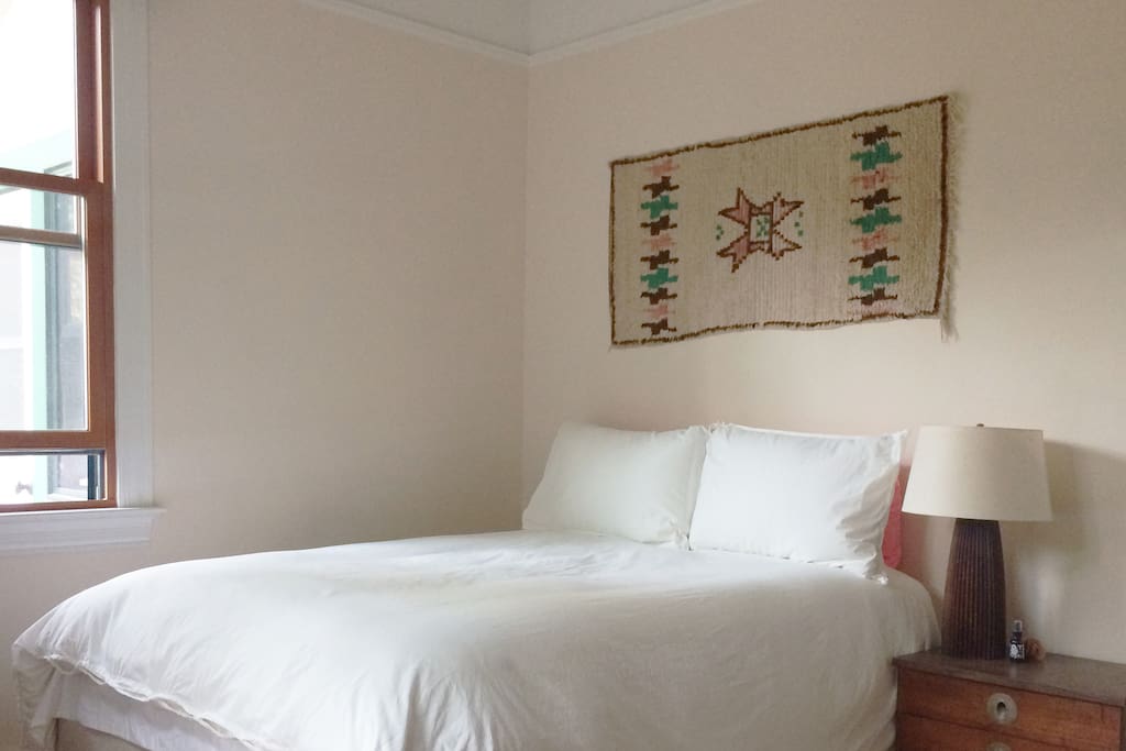 Sunny room that over looks a garden with a Queen bed.