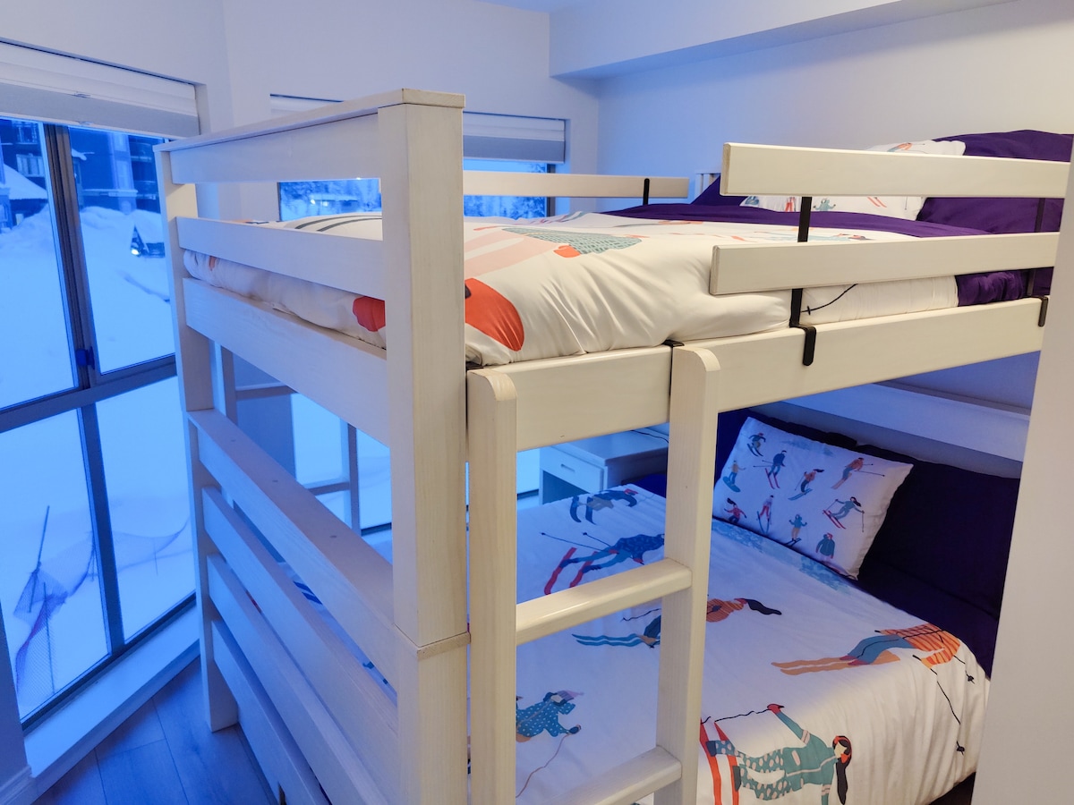 Cama queen sobre la litera Queen con escalera a ambos lados. 