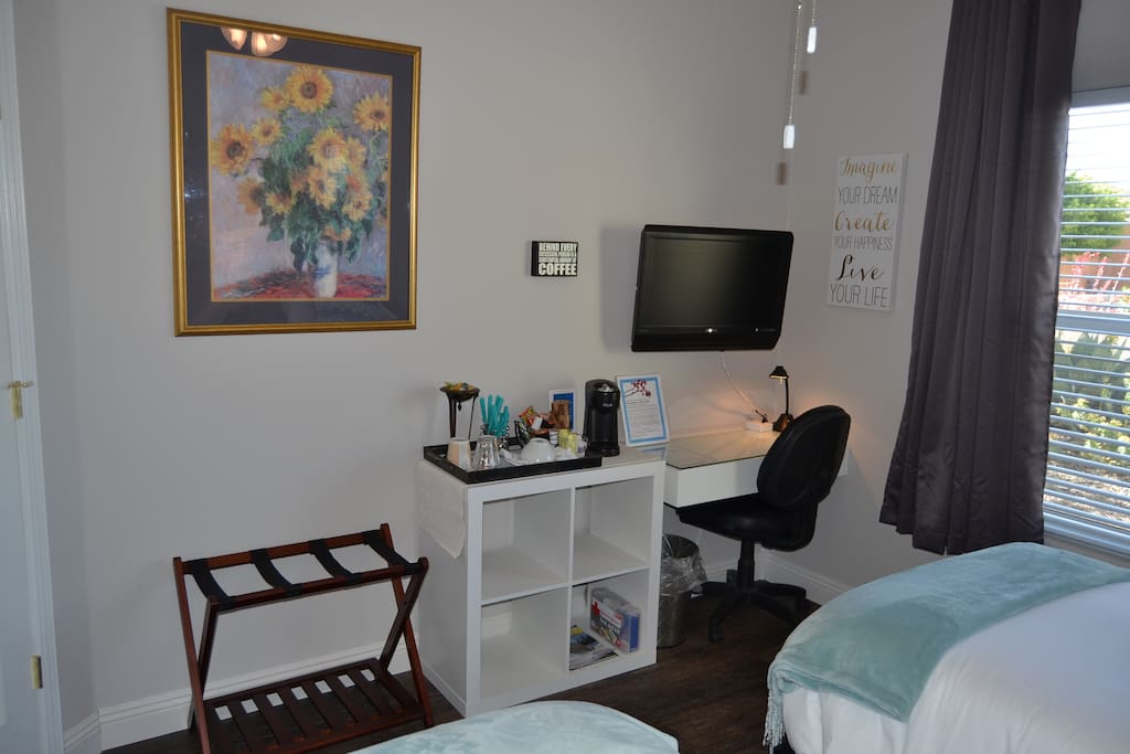 TV with Roku, desk and coffee maker with snacks