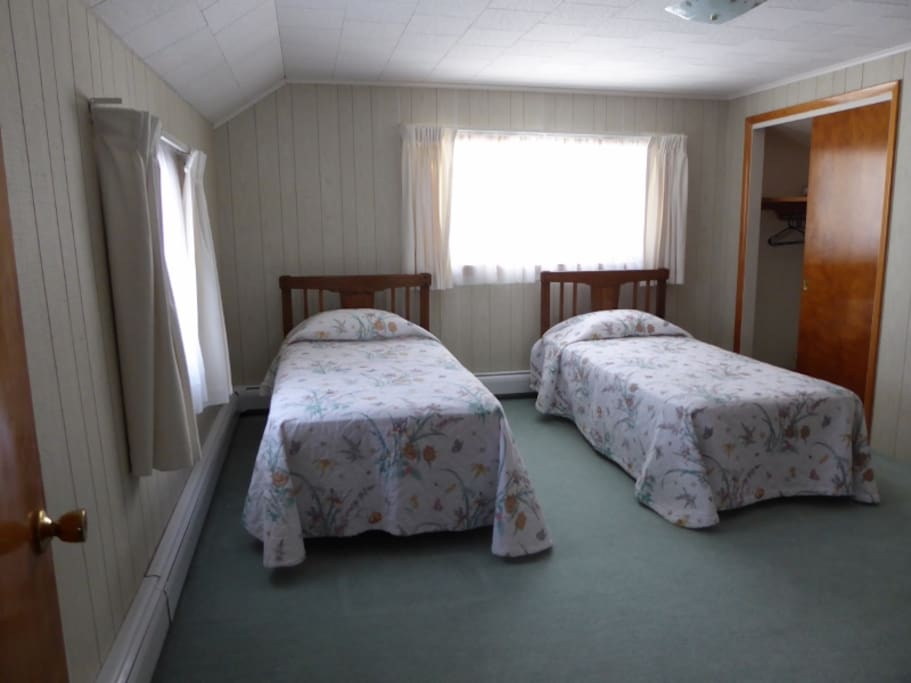 Two twin beds in this spacious upstairs bedroom.