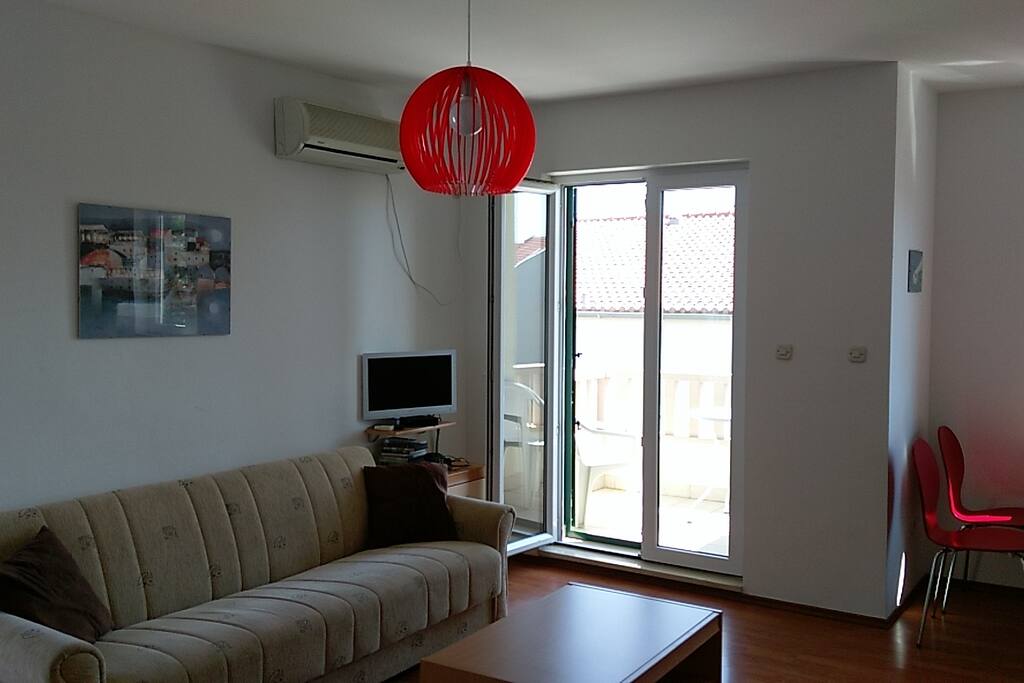 Open plan living room, showing balcony to front with table and two chairs