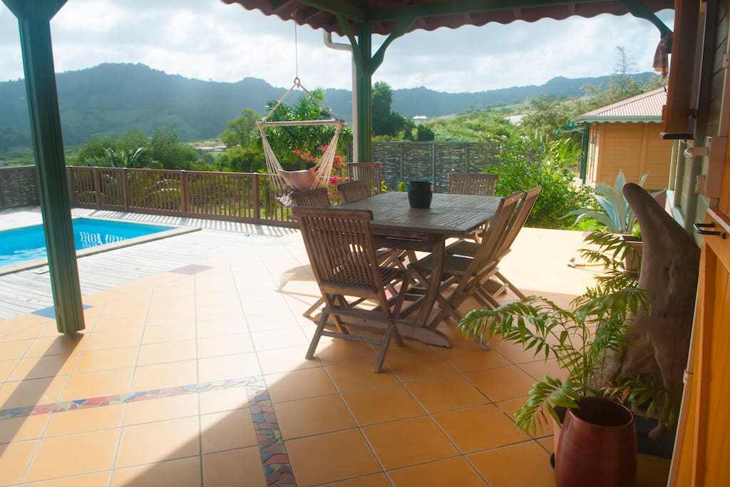 coin repas ; doucement ventilée, laissez votre regard se perdre dans la verdure et le bleu de la piscine.