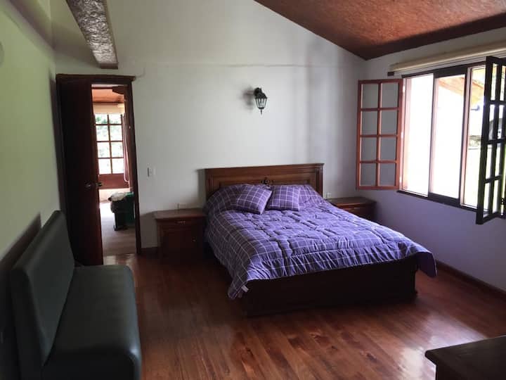 Bedroom 1 with a queen-size bed, sofa with baby rail, fireplace, and bathroom