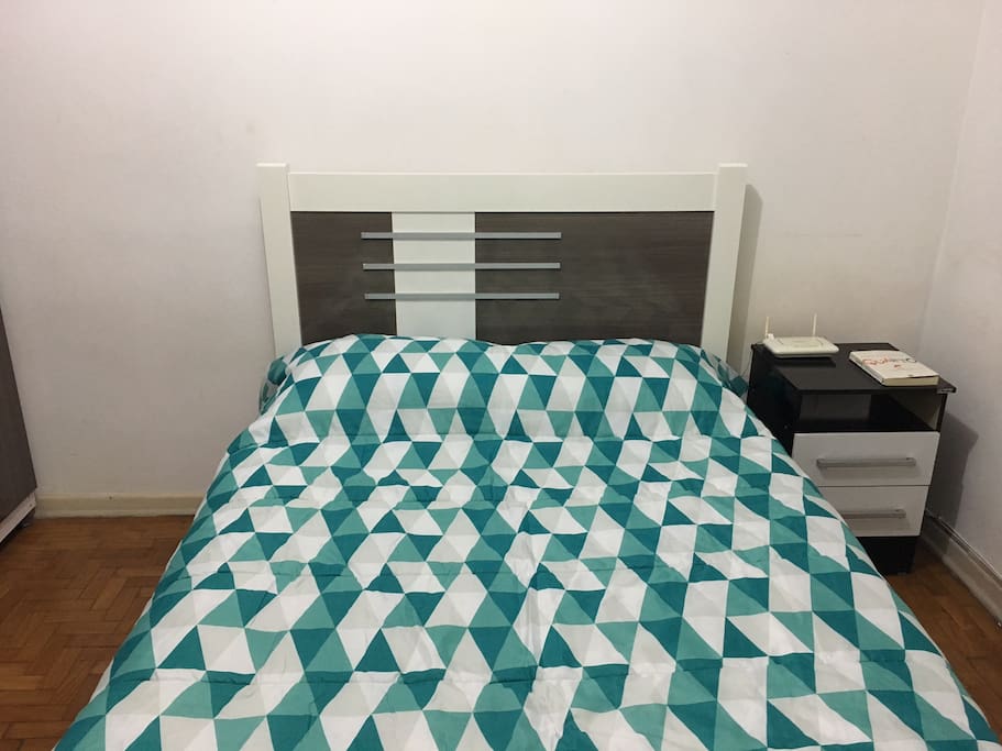 A full size bed with two pillows, sheets and duvet.