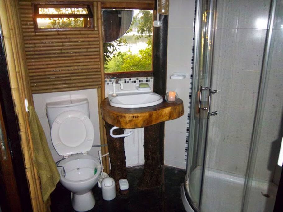 Baño rustico con vista al lago