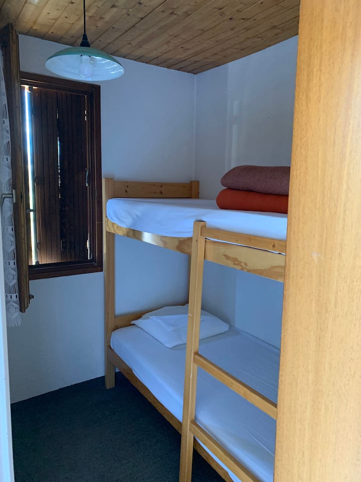 Ხის სახლი ორსართულიანი საწოლით, ფანჯრით და კარით 