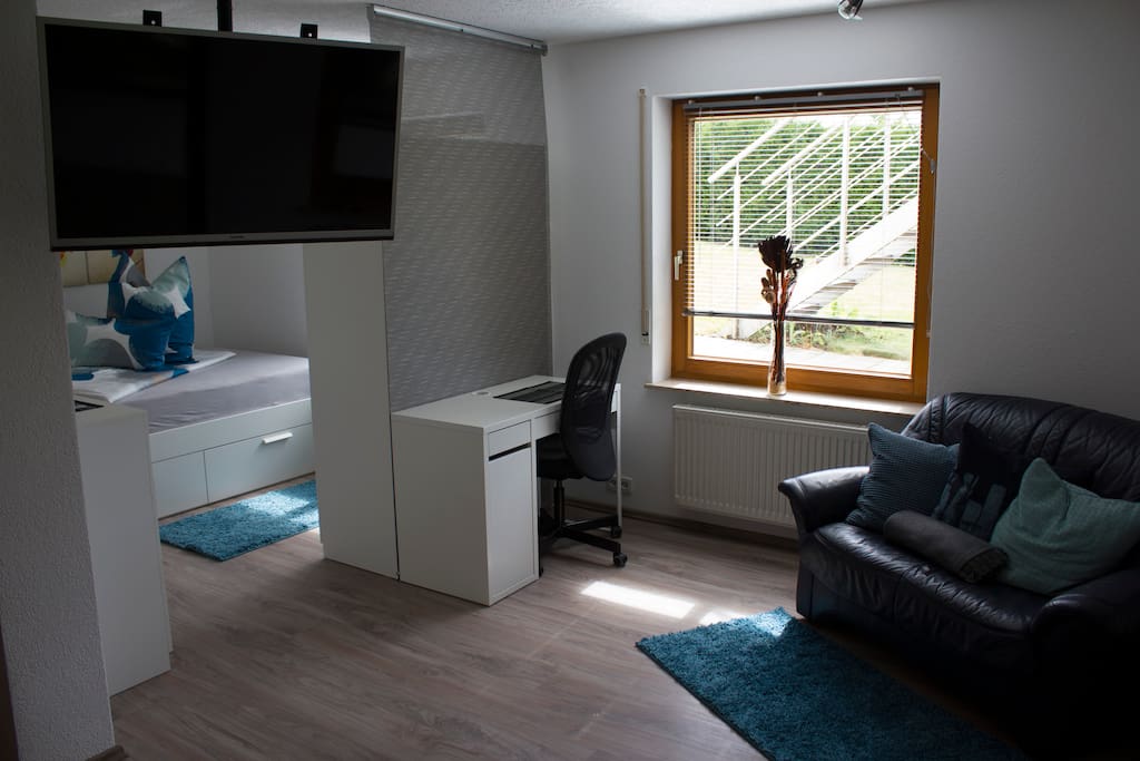 Wohnbereich mit Arbeitsplatz und Zugang zum Schlafbereich