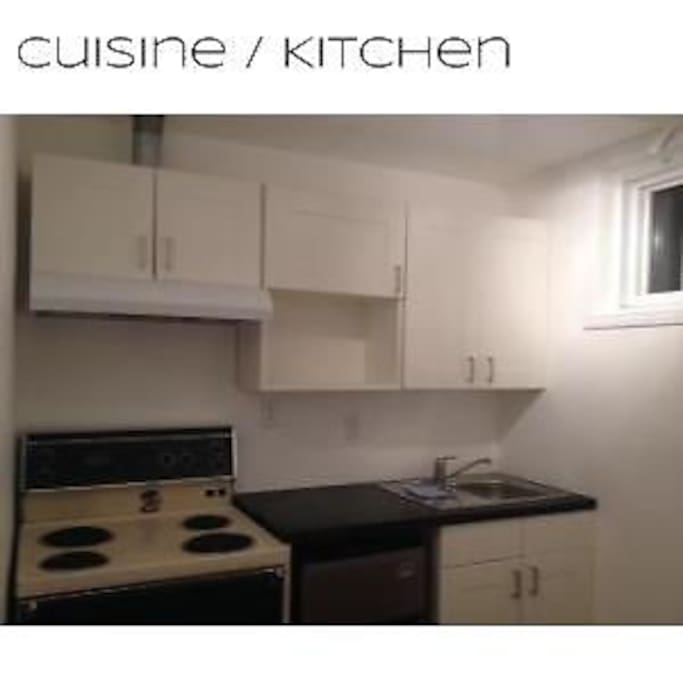 Kitchen with fridge, stove, cabinets with dishes and pots to cool.