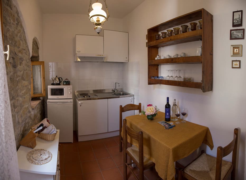 die Küche mit Tisch und Sesseln, Kühlschrank, Mikrowelle und Elektroherd