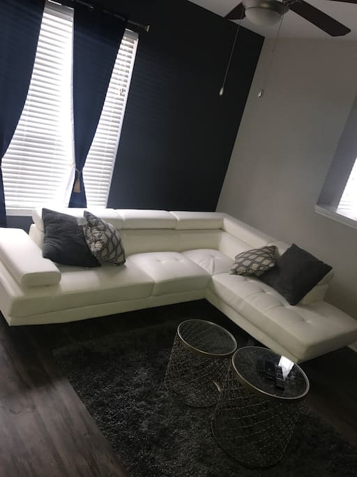 White leather sectional couch with adjustable headrest and armrest.