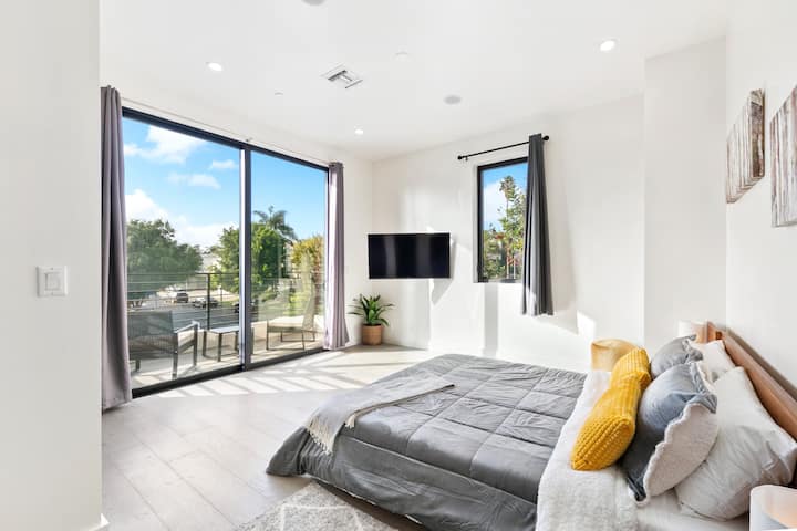 Útulná spálňa s plyšovou manželskou posteľou, mäkkou posteľnou bielizňou a upokojujúcou výzdobou. Veľké okná ponúkajú krásny vonkajší výhľad, ktorý zaplňuje priestor prirodzeným svetlom a pokojnú atmosféru pre dokonalý oddych.