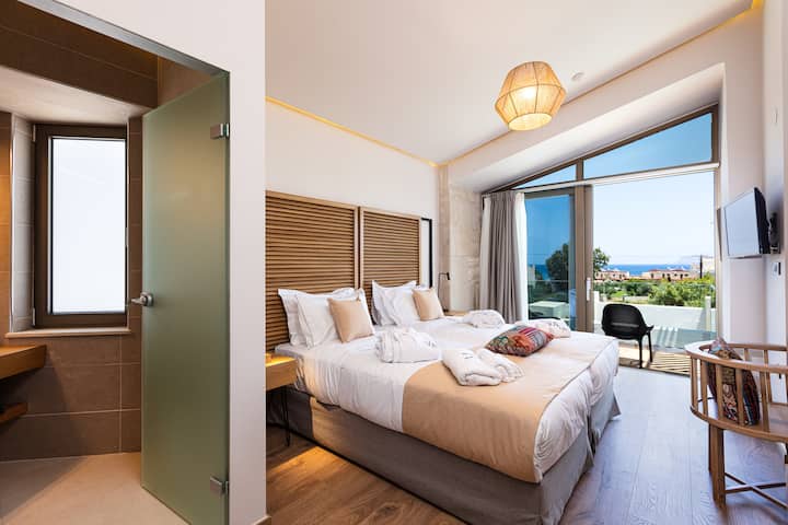 חדר שינה זוגי בקומה הראשונה עם מרפסת פרטית וחדר רחצה צמוד.