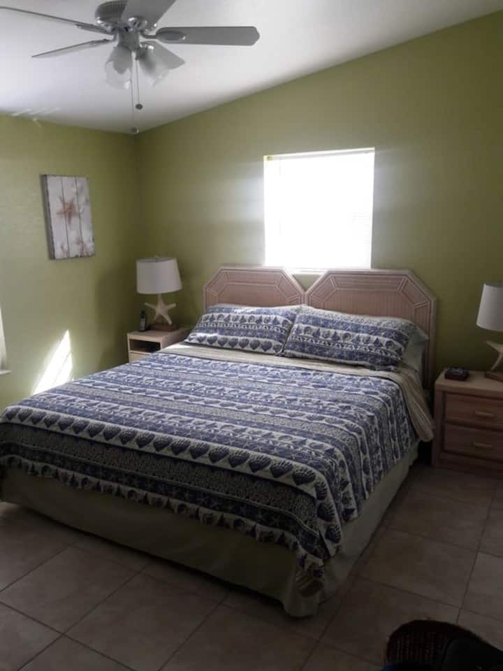 Dormitorio principal con cama tamaño king y TV (no se muestra)