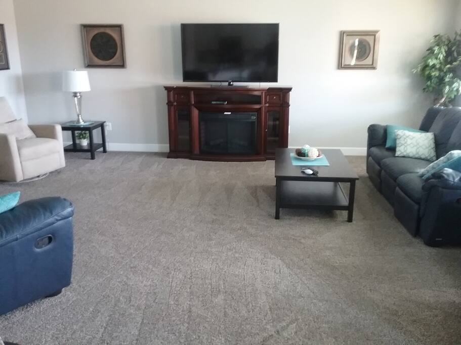 Comfortable living room with 60" TV with DirectTV and fireplace.