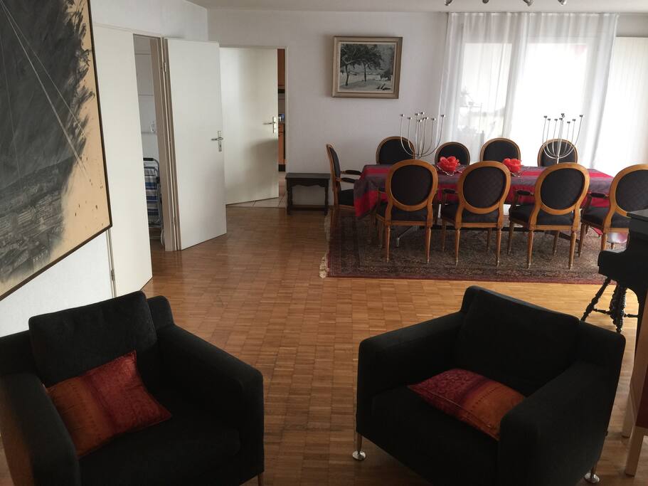 The new living room has black armchar, red sofa and a red carpet
