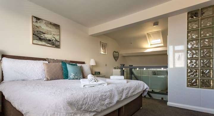 Elegante dormitorio con tocador blanco, armario y cómodo baño privado