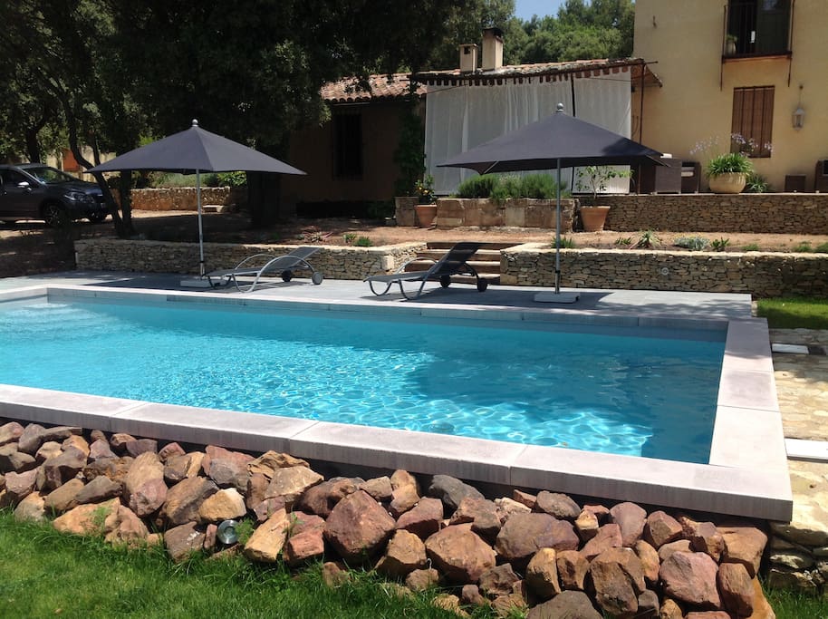 La piscine avec au fond la maison.