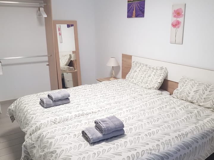 Tercer dormitorio Habitación con dos camas 0.90, 2 mesitas de noche,  armario, con estantería abierto,  espejo y ventilador de techo programable con mando velocidad y tiempo,  con ventana que da a la parte delantera de la casa.