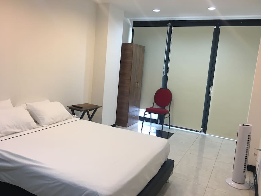 Comodo espacio con ventilador, mesa y silla auxiliar