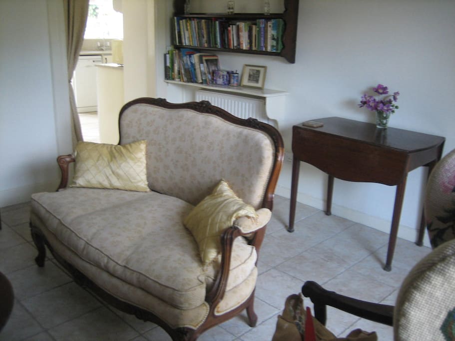 The front living room is bright and well-furnished. There is a large collection of books about Dorset