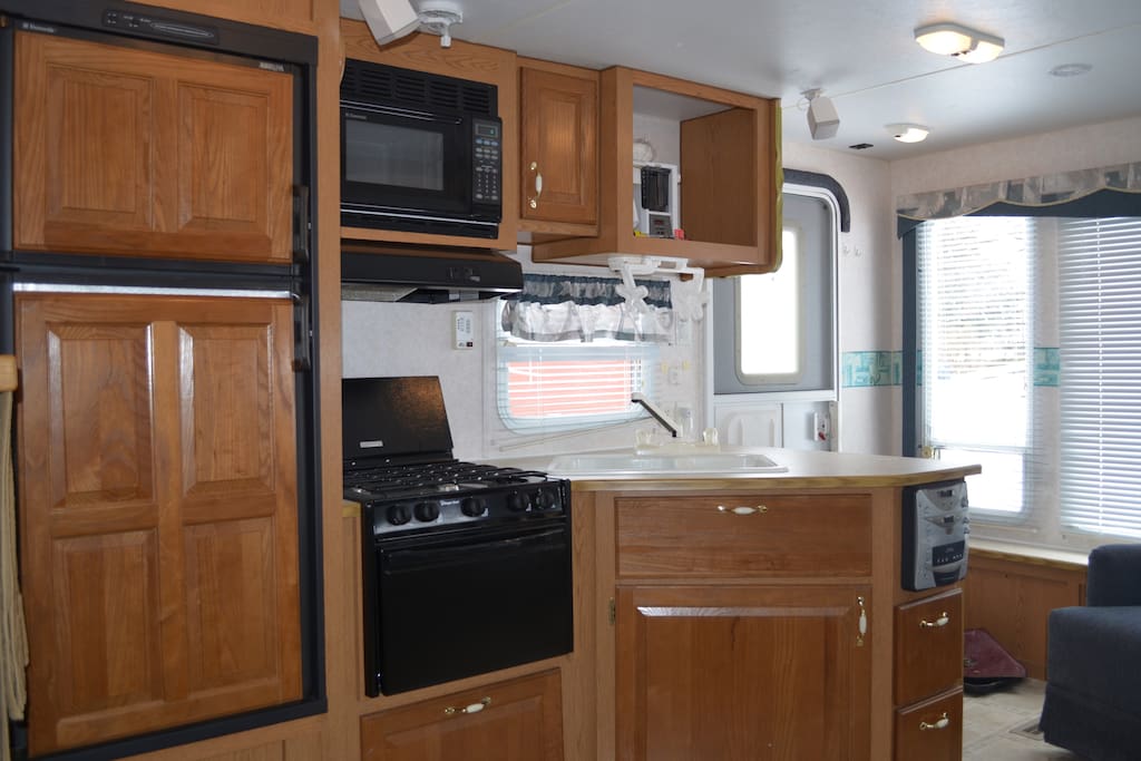Compact kitchen complete with refrigerator, running water and propane stove.