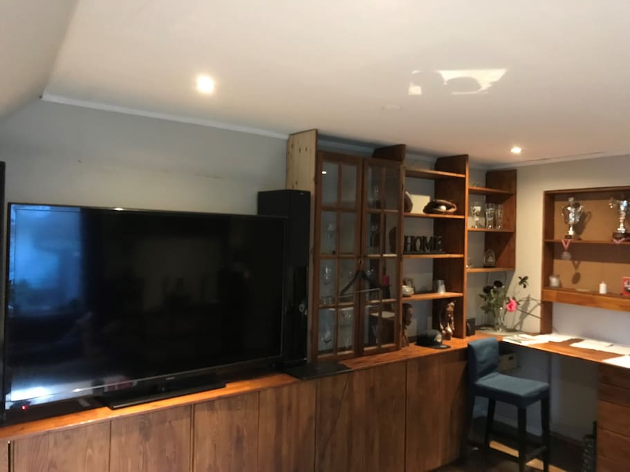 Living room with utilities like wine glasses. Also working space for laptop