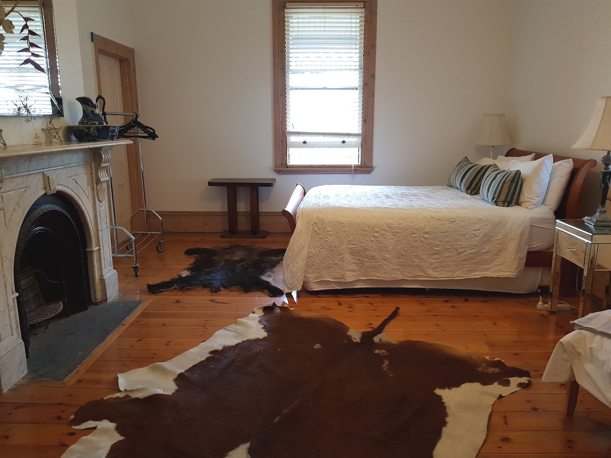 Slaapkamer 3 met een queensize bed , een marmeren open haard en de badkamer direct tegenover de kamer. In deze kamer staat ook een eenpersoonsbed