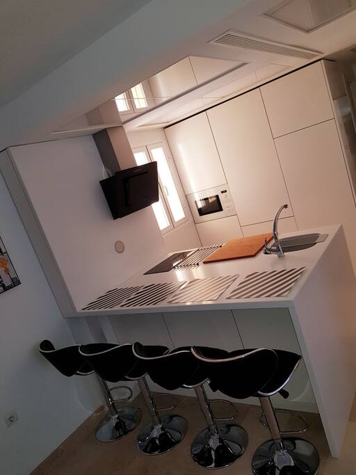 La cocina está completamente equipada: vitro de inducción, campana extractora, nevera con congelator, lavadora y microondas grill