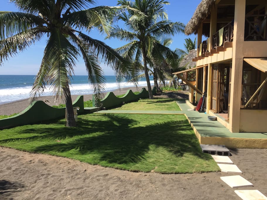 Side view of house with front lawn leading out to the beach