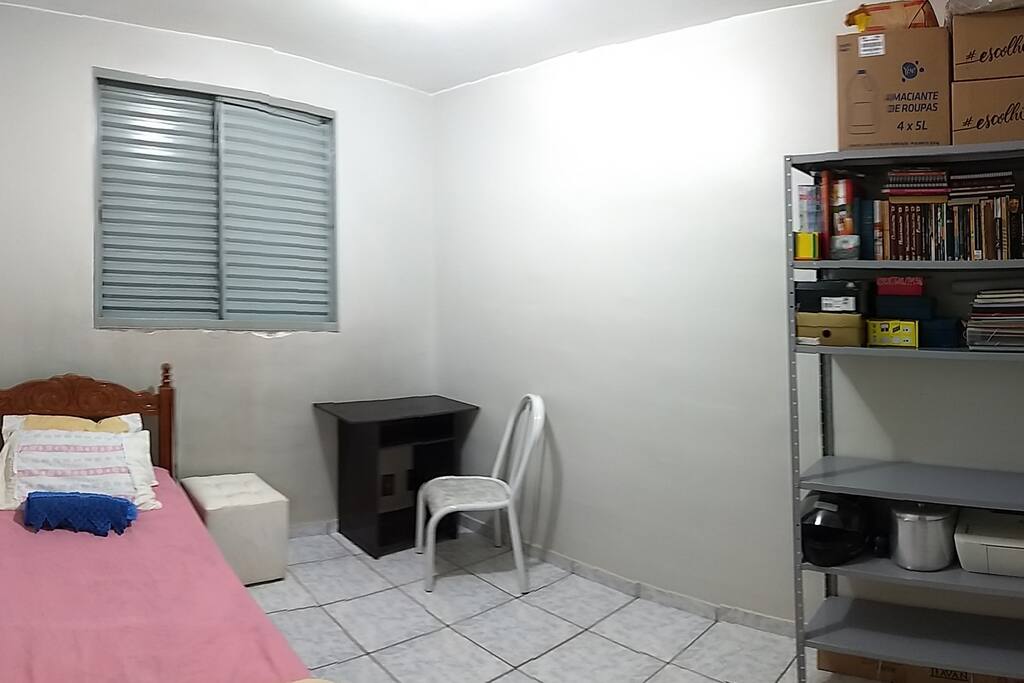 Cama de solteiro, puff de apoio, mesa de apoio com cadeira, espaço na estante para apoio, tomada junto à mesa.
Na estante estão meus itens de uso esporádico.