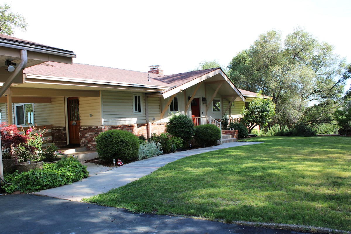 The exterior of the home features a welcoming entrance with a covered porch and brick accents. Lush greenery surrounds the property, complemented by manicured lawns and decorative plants. The driveway leads to the entrance, creating an inviting atmosphere amidst a serene outdoor setting.
