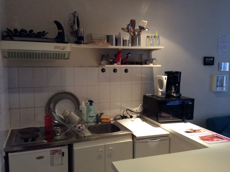 My kitchen - which is actually attached to the living room. In here you will find a fridge, a washing machine, a coffee maker, a kettle, a blender and a microwave that turns into an actually oven if needed.