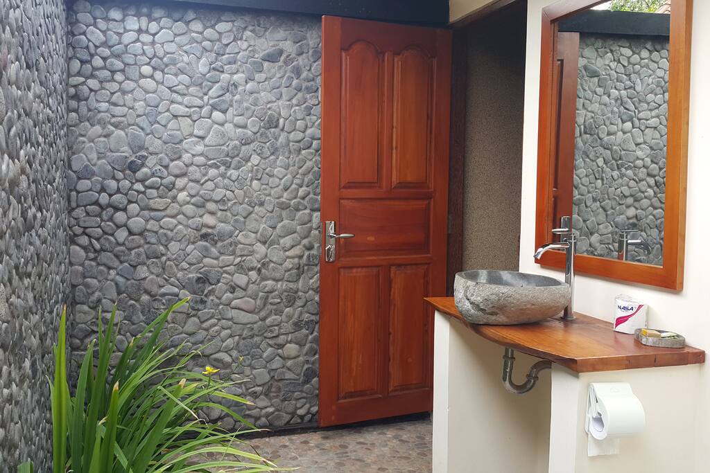 Open air bathroom with stone sink, wood from our land, and stone walls