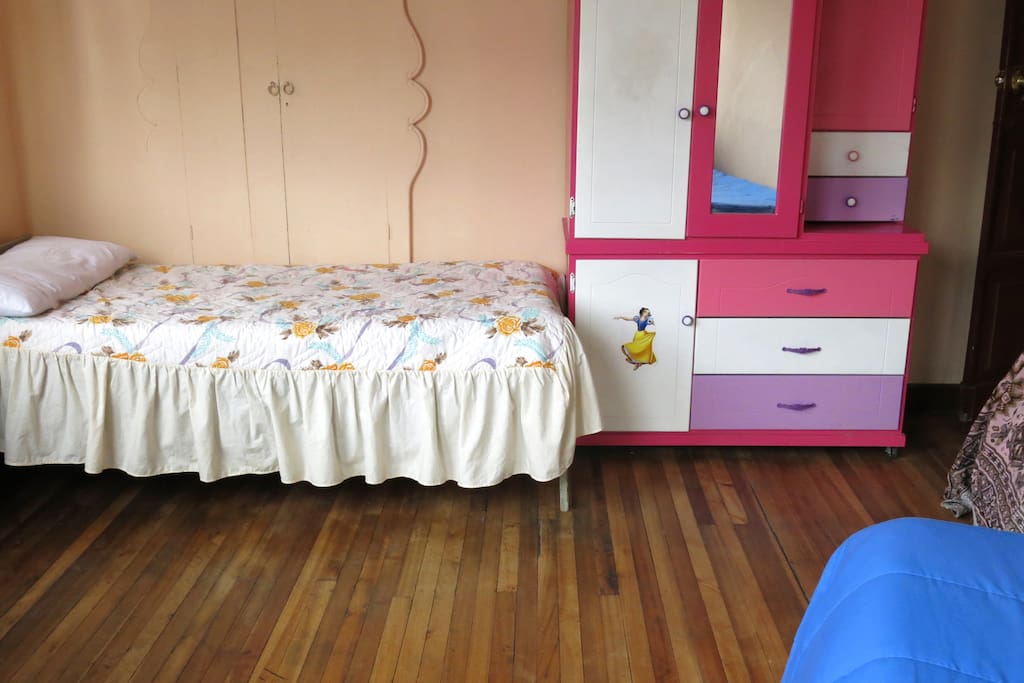 Habitación con una cama individual para 1 o 2 personas, con armario empotrado (sin el armario rosado) , velador, sillones y balcón con vista a la calle