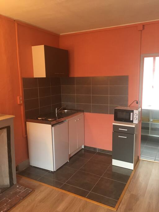 Une kitchenette équipée avec frigo et micro-onde