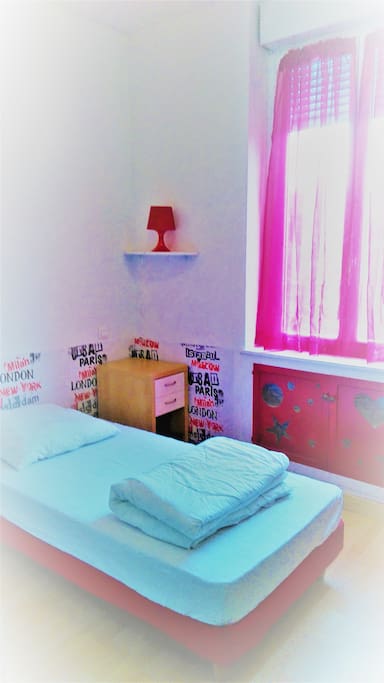La chambre rouge : le lit et la table de nuit.