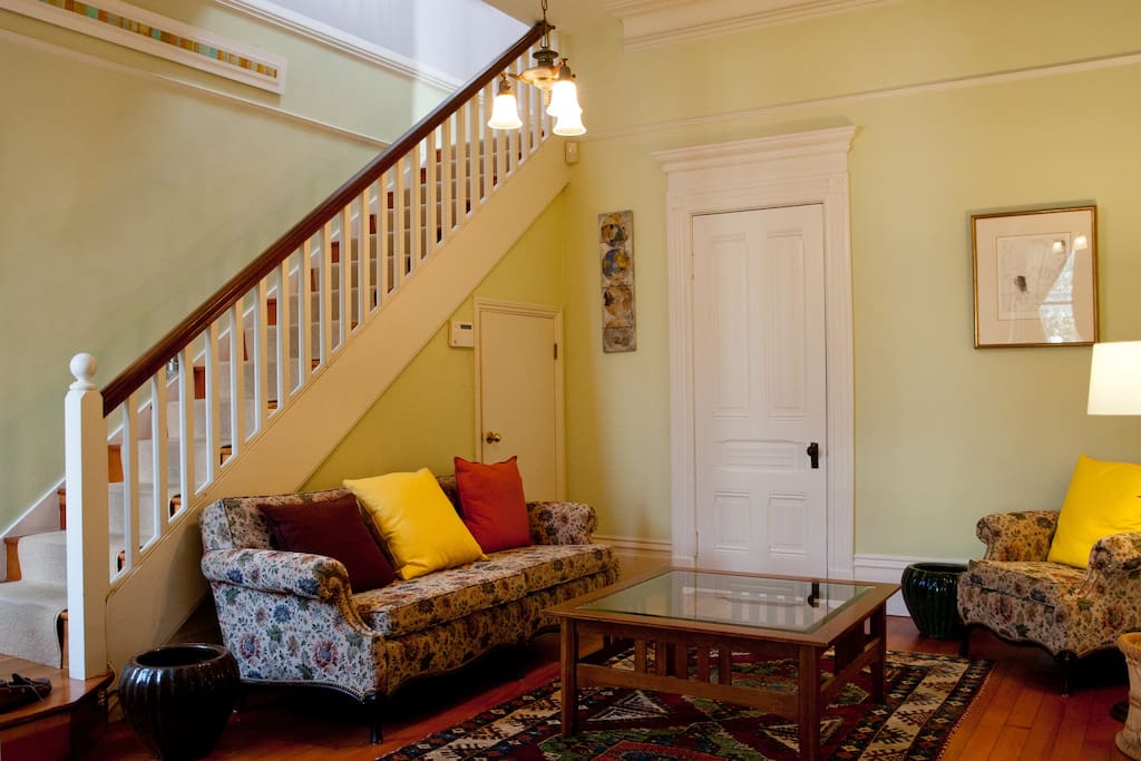 Parlor room w/ stairs leading to upstairs bedrooms and bath.