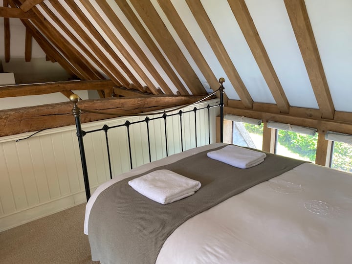 Sovrum 4 - en mezzaninnivå med utsikt över loungen med en king size-säng