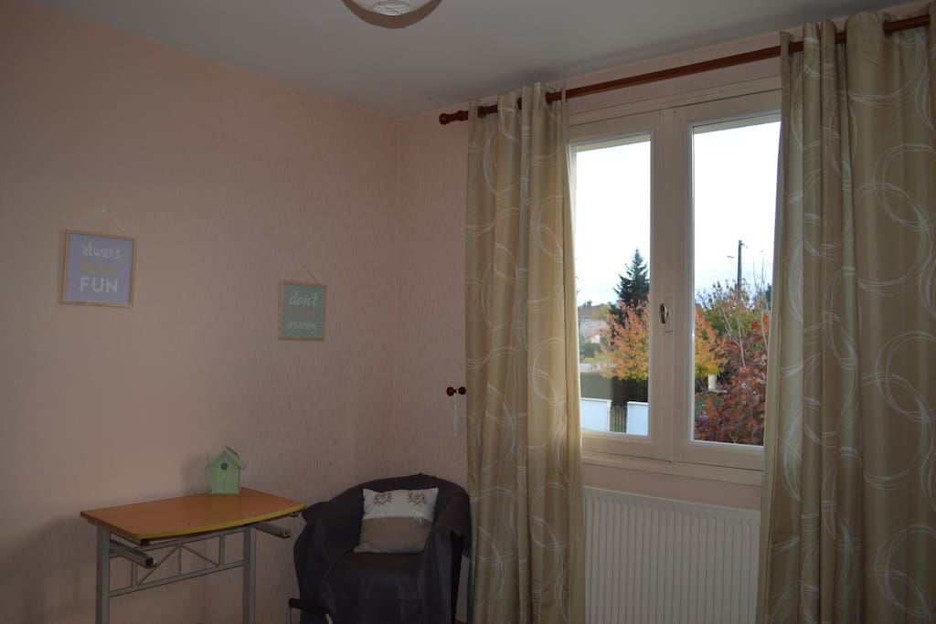 Chambre lumineuse avec vue sur le jardin.