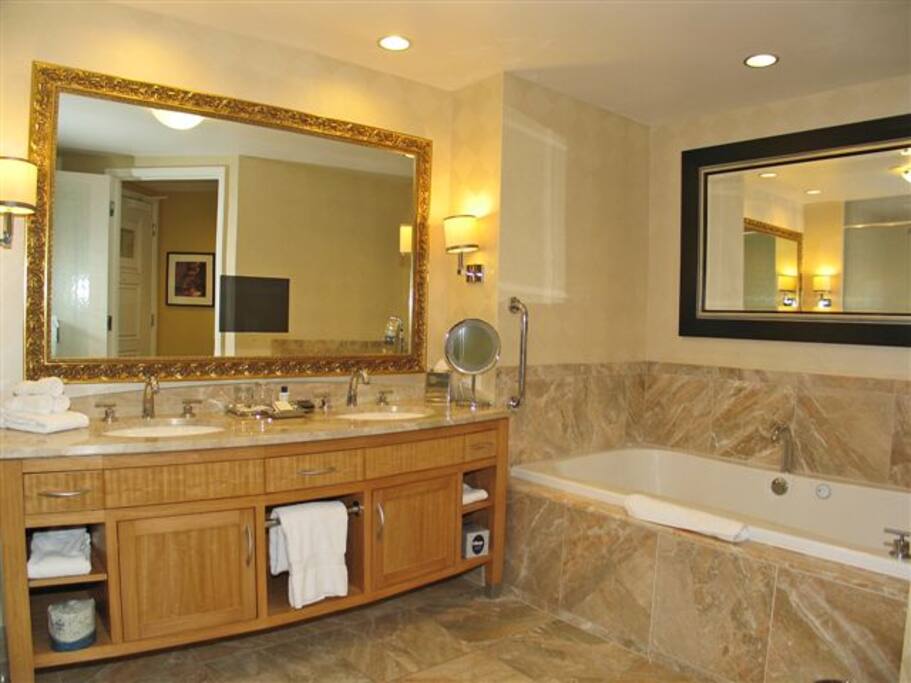 Beautiful Breccia Onniciata marble encapsulates the bathroom complete with double sink vanity, 6 foot whirlpool tub