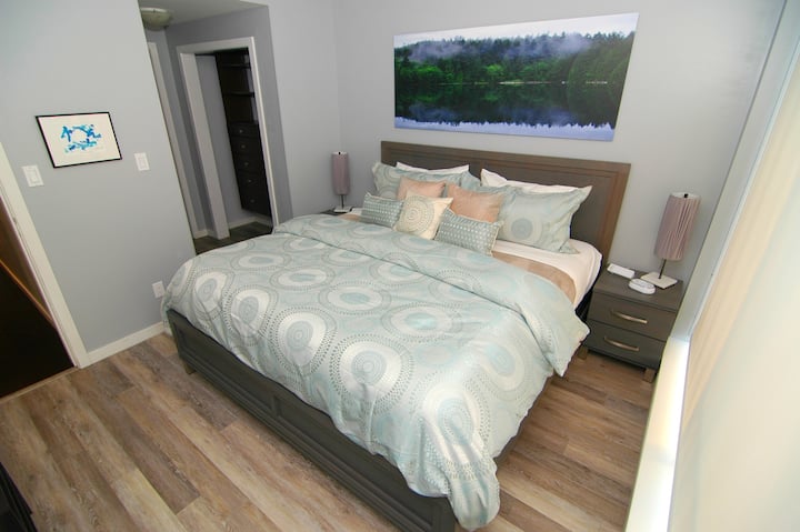 Master bedroom: Luxurious KING-size bed awaits, comfy chair, reading light, 55 inch Samsung Ultra HD 4K curved smart TV
