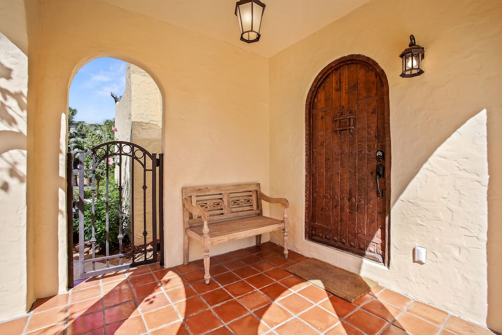 Entry porch with antique wood door and vintage iron gate